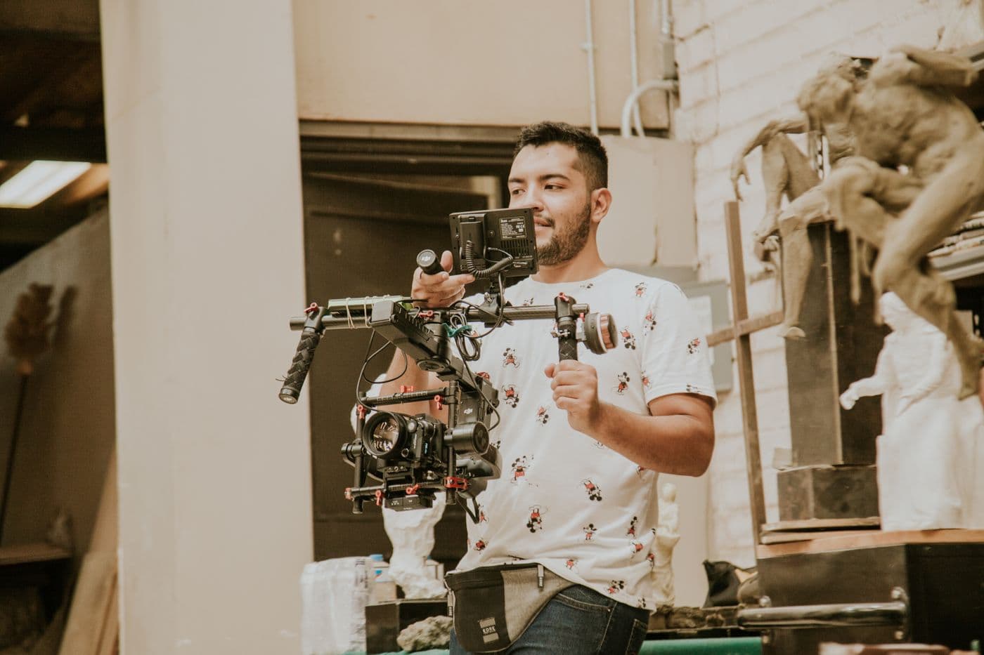 Un cadreur filme en décor intérieur avec une caméra montée sur stabilisateur