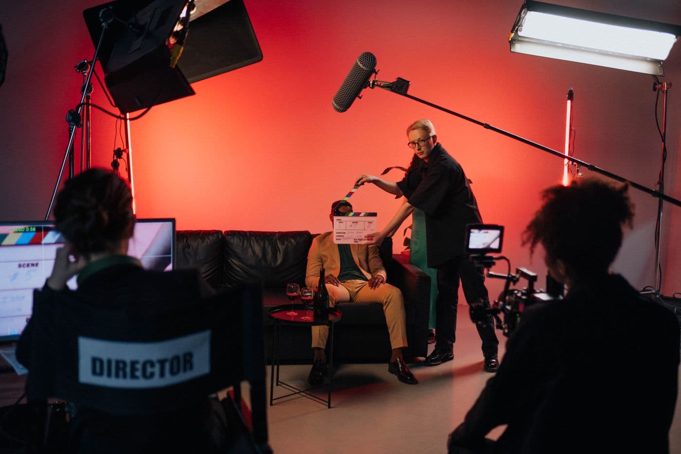 Crew on a studio set, slate in front of the performer, lights and monitor set up