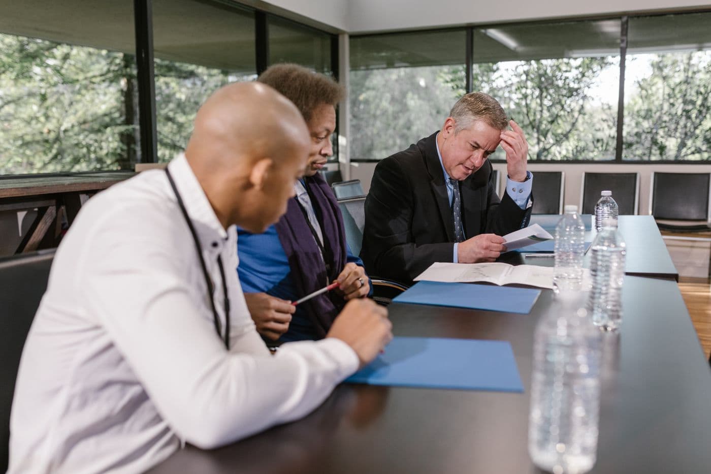 Équipe réunie autour d'une table de réunion, examinant des documents imprimés