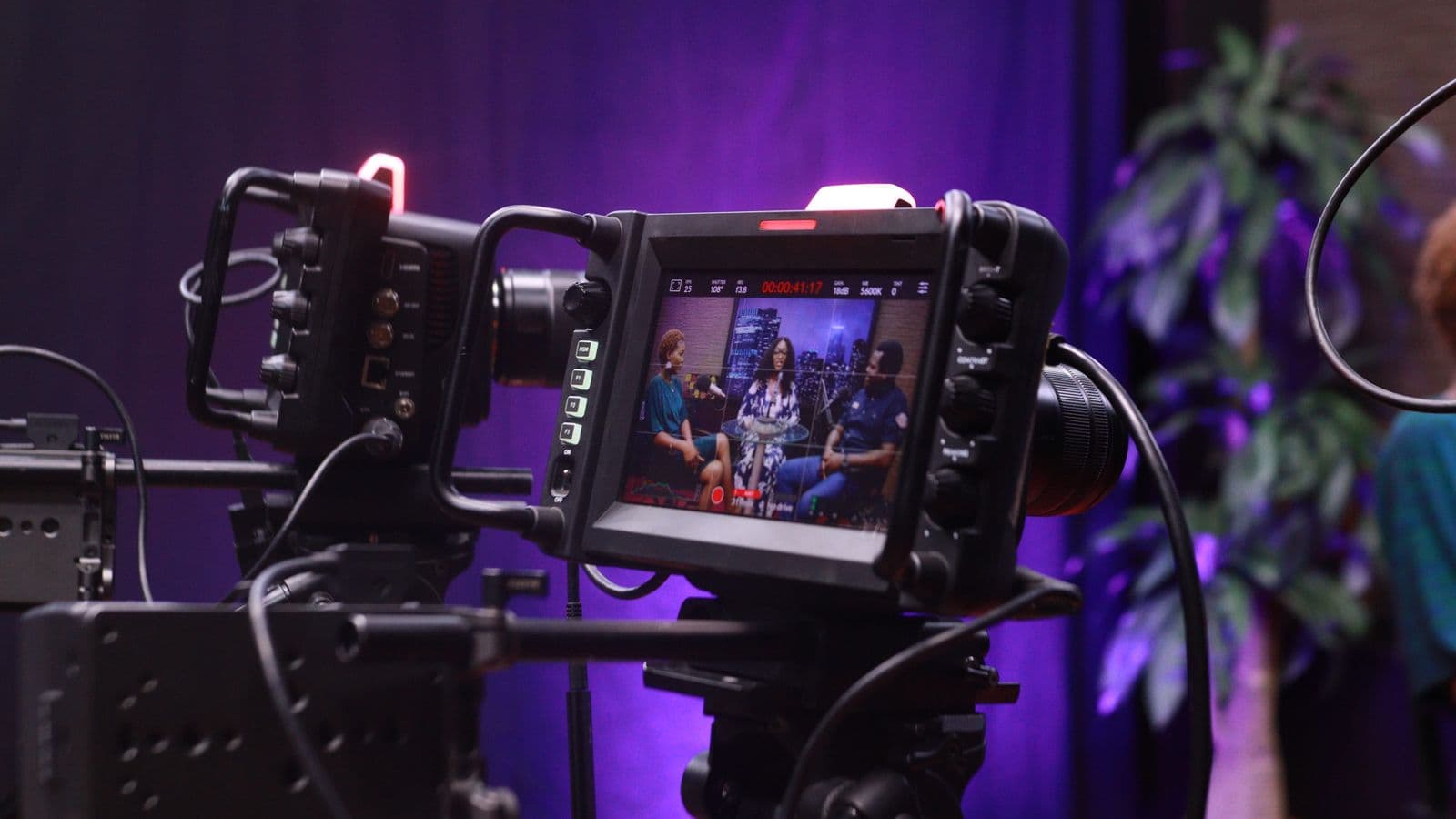 Un moniteur de caméra affiche une interview en cours de tournage sur un plateau éclairé