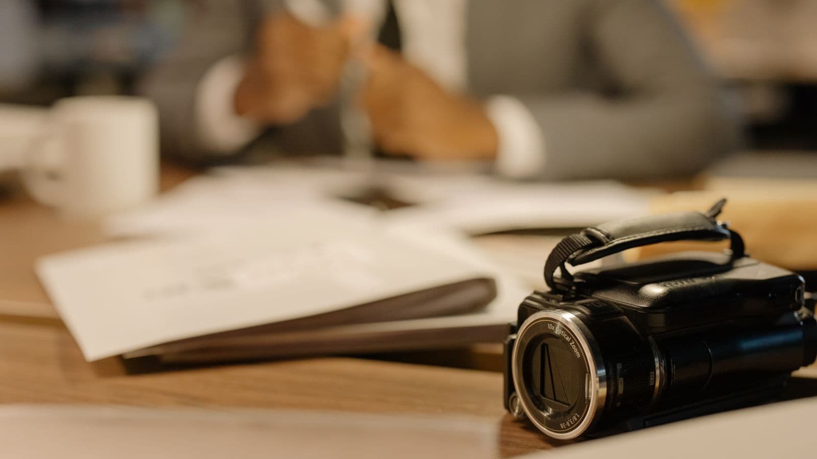 Caméscope posé sur un bureau, à côté de documents de production